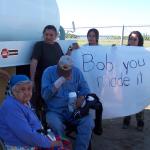 When he arrived at the airport, there was people waiting with a banner.