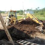The tractor that is being used, to dig the ground to place the pipes in.