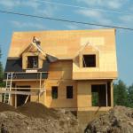 A worker on the building, as they start to put the shingles on the roof.