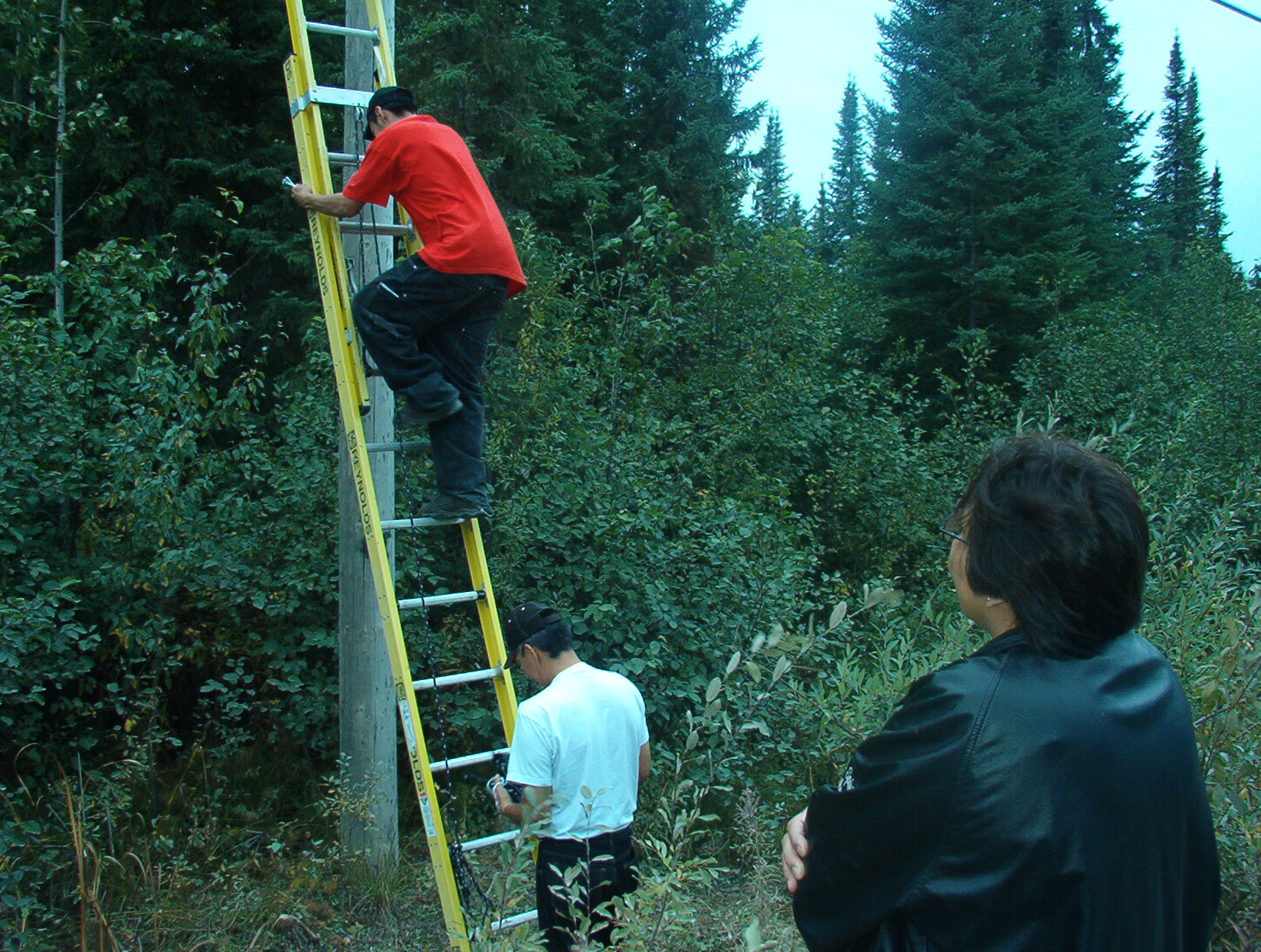 Darlene watches as Brian and Oscar do some technician work.