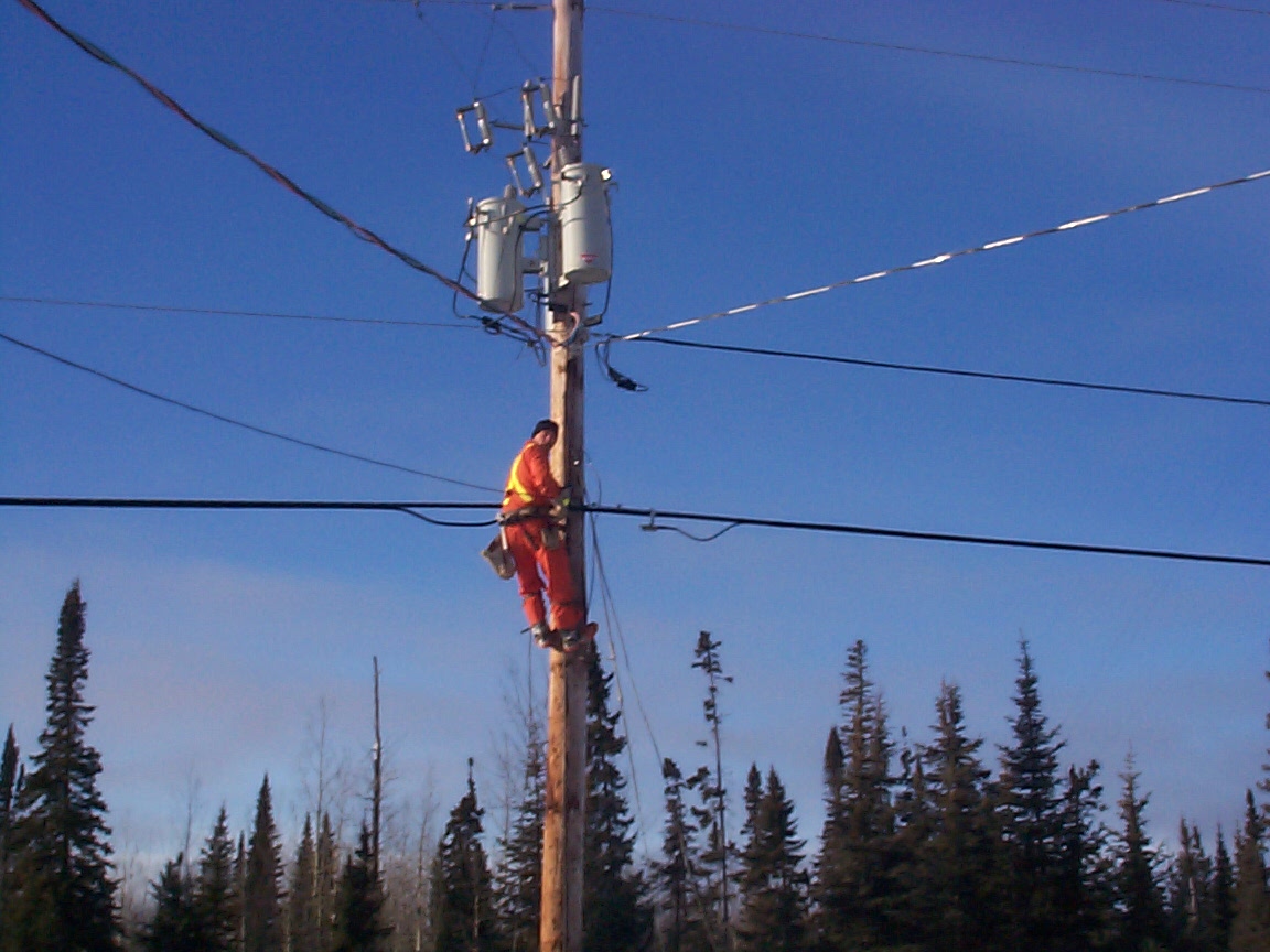 Climbing the pole to put the wiring cable in place.