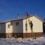 Climbing on top the roof to place the wiring for internet access to the homes in North Spirit Lake.