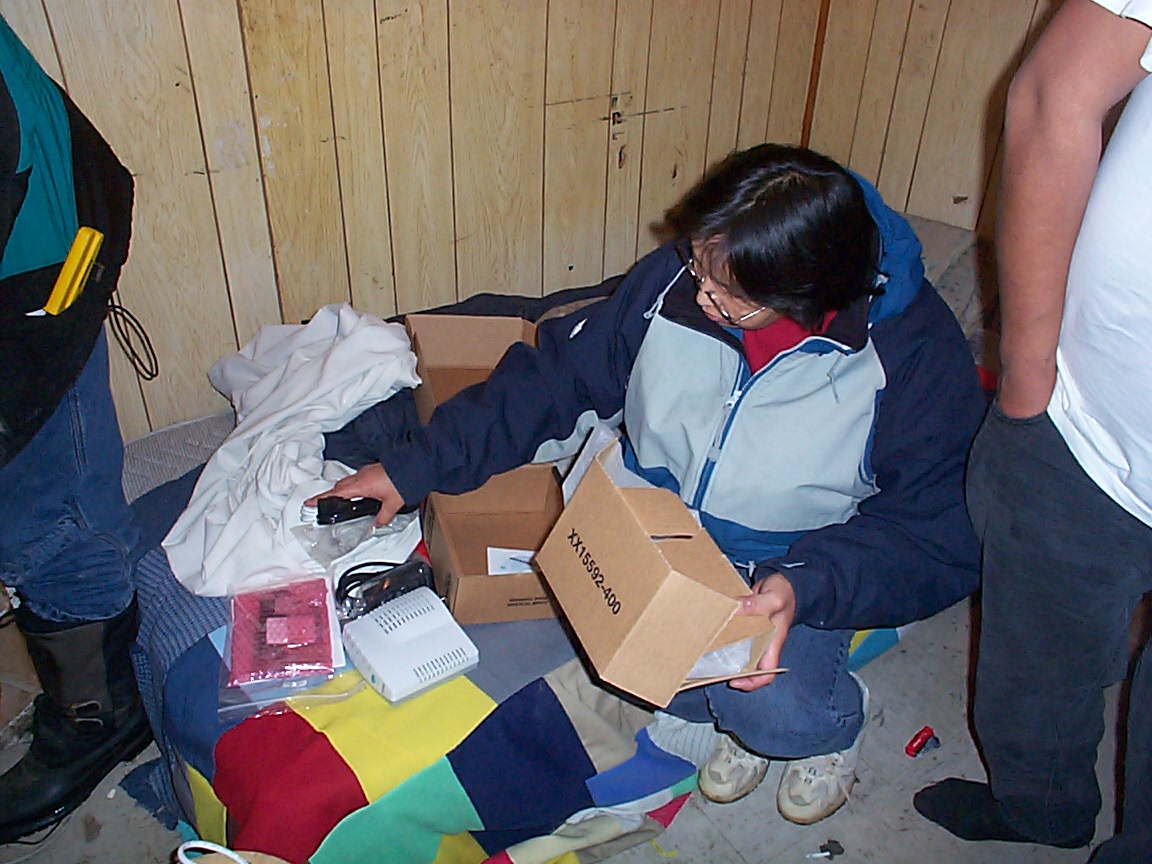 Darlene unpacking the cable modem at Patrick Kakegamick's place.